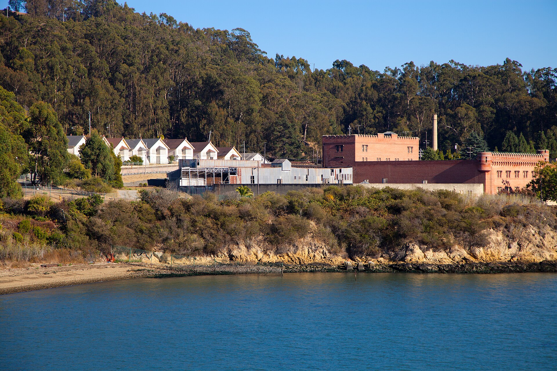 The brick Winehaven cellars and a row of worker cottages on the hillside above San Pablo Bay
